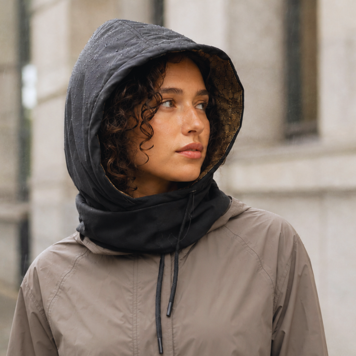 Woman wearing a graphene-lined hooded scarf outdoors in cool weather.
