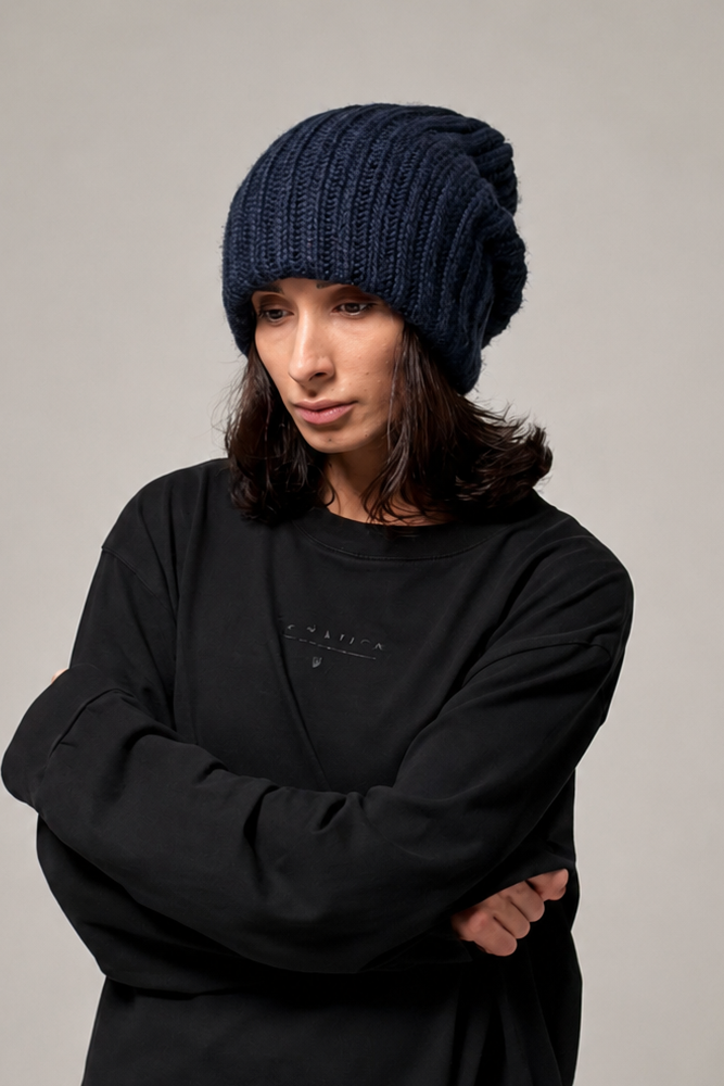 Black slouchy knit beanie showing chunky texture and flexible folded edge
