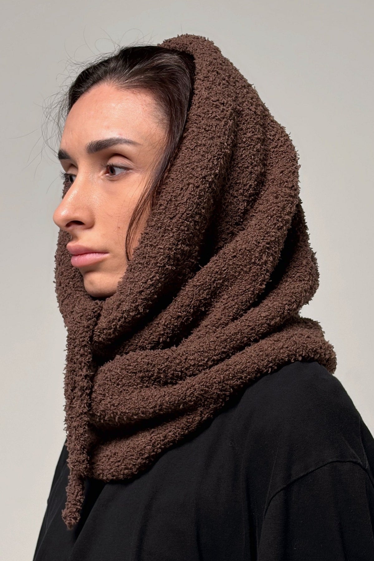 Brown knit cowl scarf styled around the neck for cold-weather layering