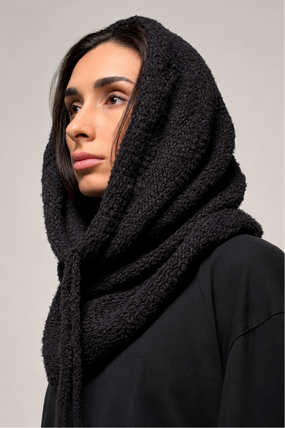 Black knit hooded cowl scarf showing pull-on shape and neck coverage