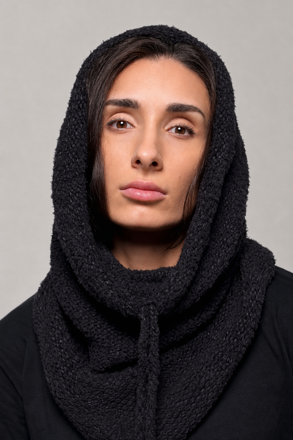 Black convertible knit hooded cowl scarf worn over the head and neck
