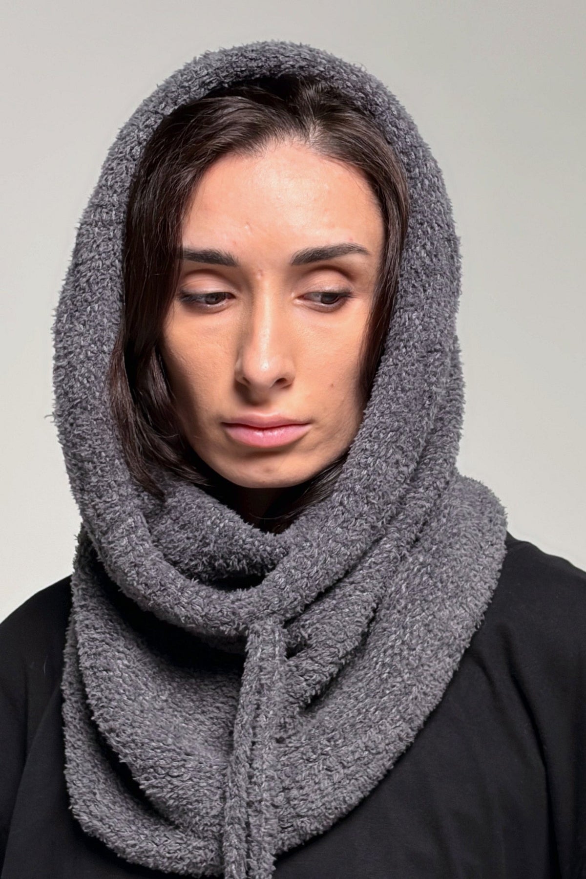 Dark gray convertible knit hooded scarf styled over everyday outerwear